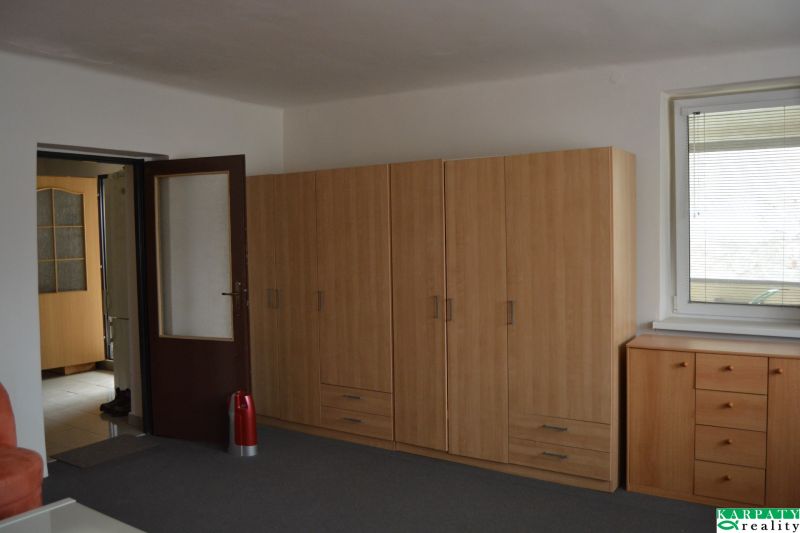 A room in a family house with brown cabinets, a window, and a door.