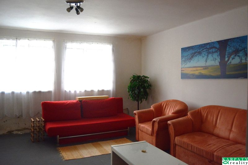 Living room of a family house with a red sofa and orange armchairs.