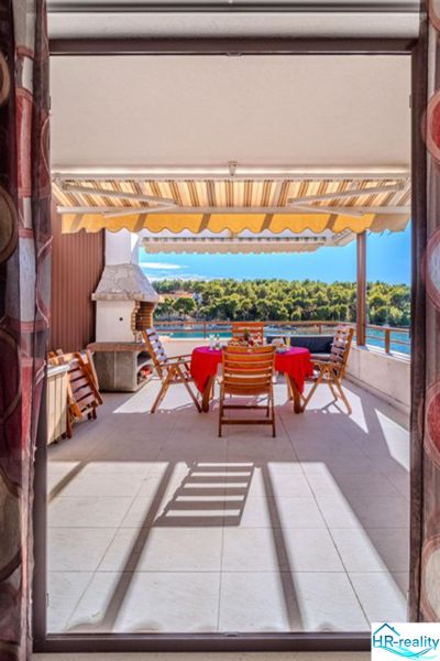Brač holiday apartment with terrace, sea view, and outdoor chairs at the table.
