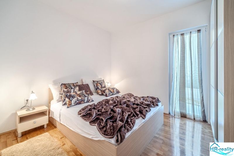 Bright bedroom with a bed and wood-decor flooring in a vacation apartment.
