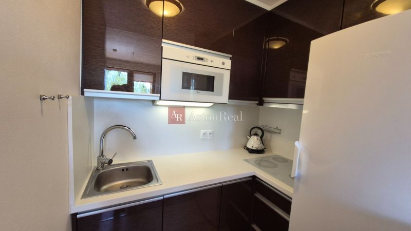 A kitchen with white appliances and dark cabinets in a Holiday Apartment.