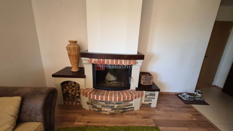 A fireplace in a recreational apartment with decorative stone and wood-patterned flooring.