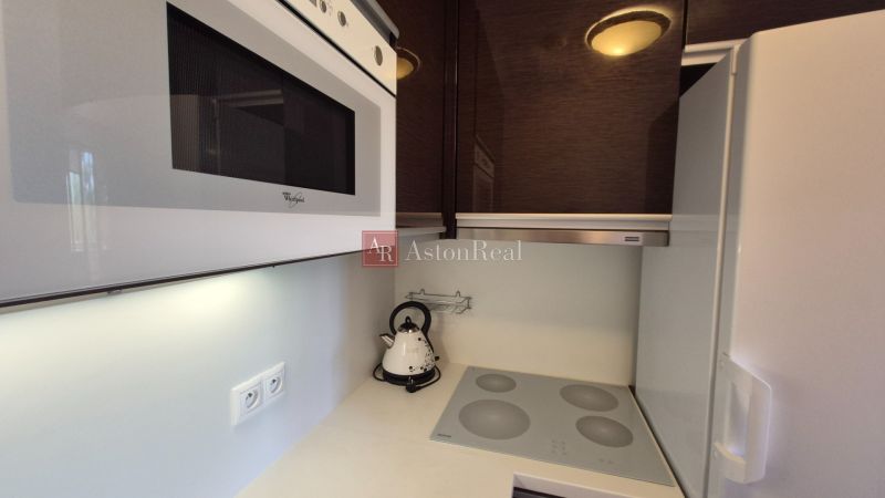 A kitchen of a holiday apartment with a microwave, a hob, and an electric kettle.