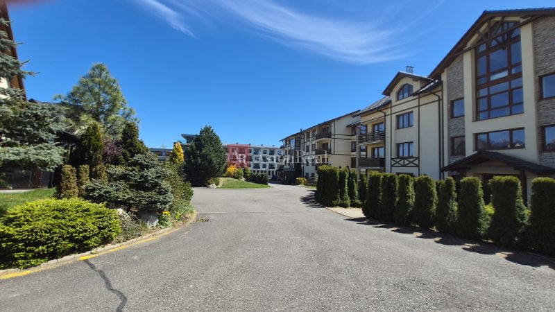 The greenery around the recreational apartments in Stará Lesná in the High Tatras under the blue sky.