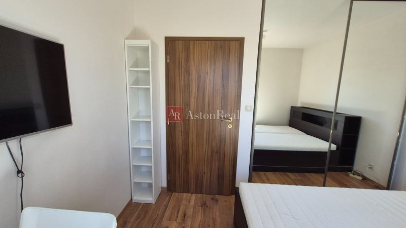 Recreational apartment with a bed, wardrobe, and wooden decor flooring.