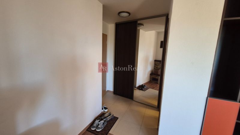 Hallway with a large mirror, footwear, and tiles in a Holiday Apartment.