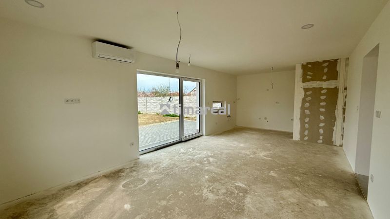 A family house with an empty room, air conditioning, and a large window to the garden.