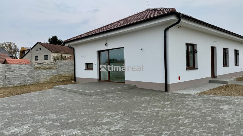 A family house on Hlavná Street in Vlčany with a white facade and a paved courtyard.