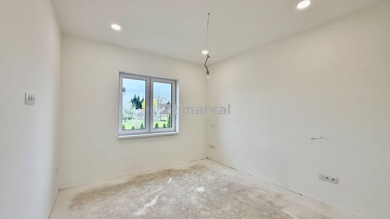 Empty room in a family house with white walls and a window overlooking the outside.