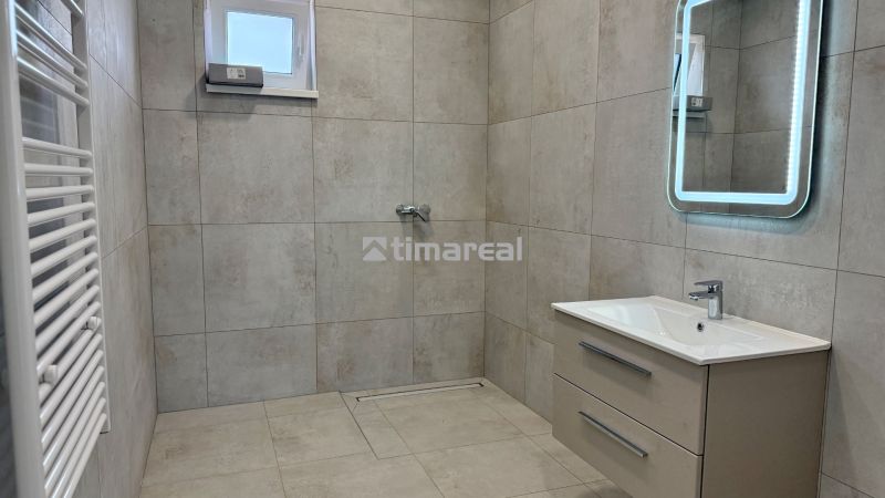 A bathroom in a family house with tiles, a mirror, and a shower corner, barrier-free access.