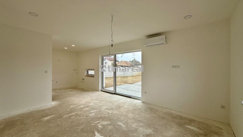Interior of a family house with sliding doors, air conditioning, and space for a kitchen unit.