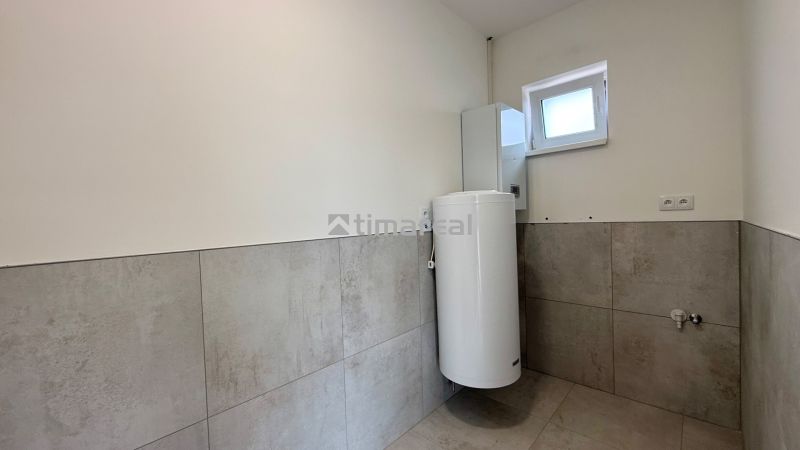 A bathroom in a family house with tiles on the walls and a boiler.