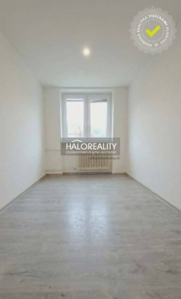 A room in a 3-room apartment with a wooden-patterned floor and white walls.