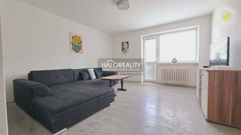 Living room with a sofa and a wooden decor floor in a 3-room apartment.