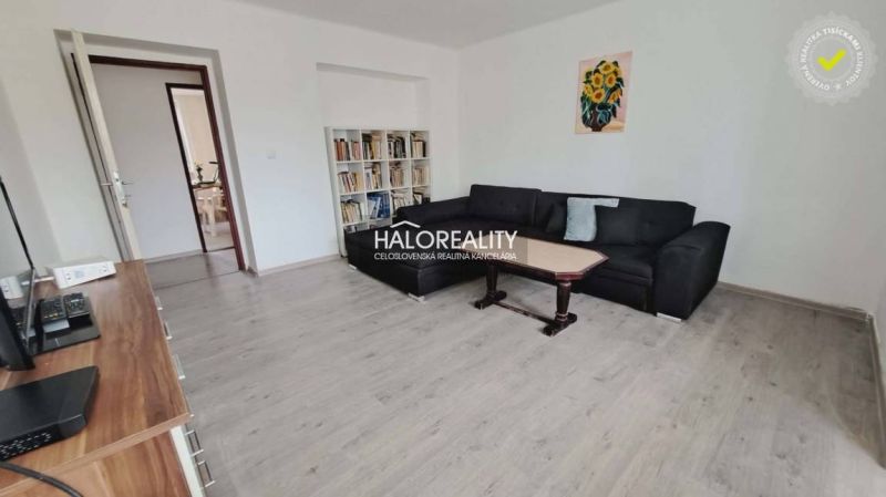 Living room in a 3-room apartment with a wooden decor floor and a comfortable sofa.