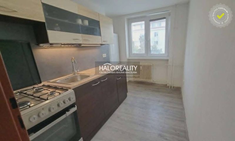 A kitchen in a 3-room apartment with a gas stove and a floor with a wood decor.