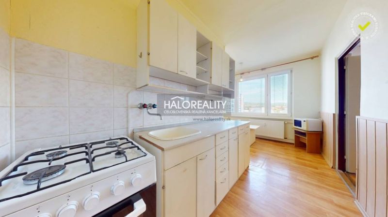 A kitchen in a 2-room apartment with a gas stove and a wooden decor floor.