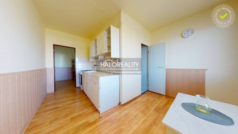 A kitchen in a 2-room apartment with a wood-patterned floor and basic equipment.