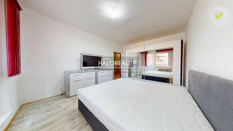 Bedroom with a white interior and a wooden decor floor in a 2-room apartment.