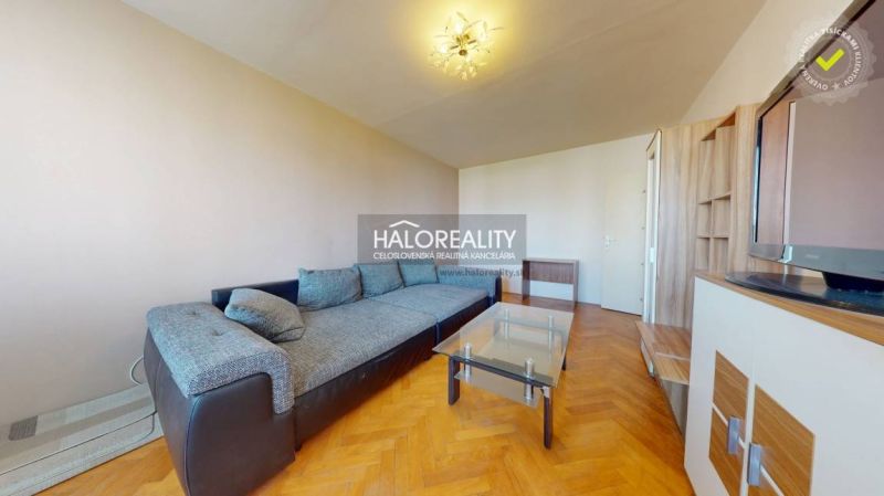Living room in a two-room apartment with a sofa and a wooden decor floor.