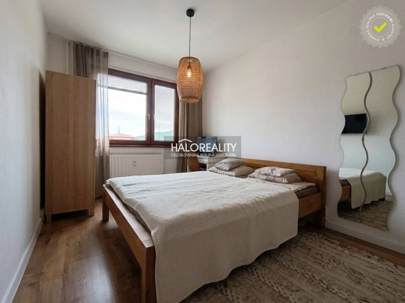 A bedroom in a 3-room apartment with a bed and a wooden decor floor.
