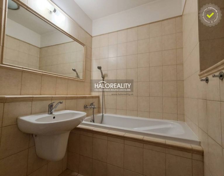 Bathroom in a 3-room apartment with a bathtub, sink, and a large mirror on the wall.