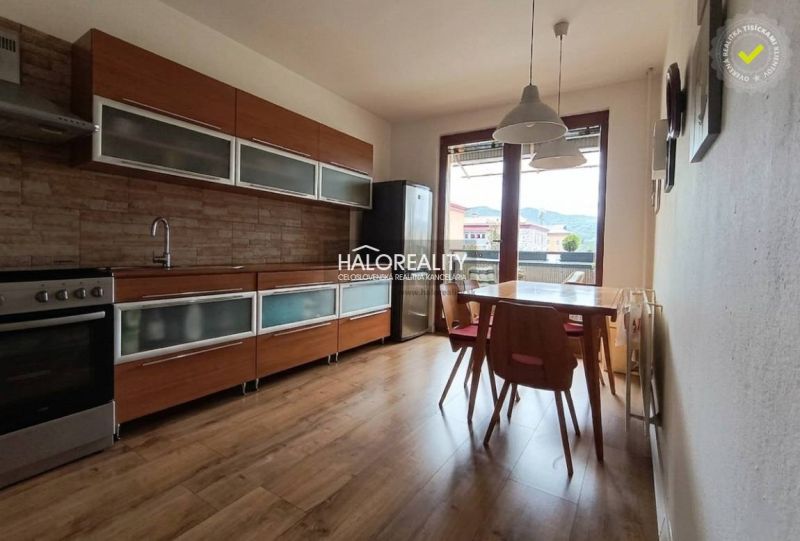 A kitchen in a 3-room apartment with a wooden decor floor and a dining table.