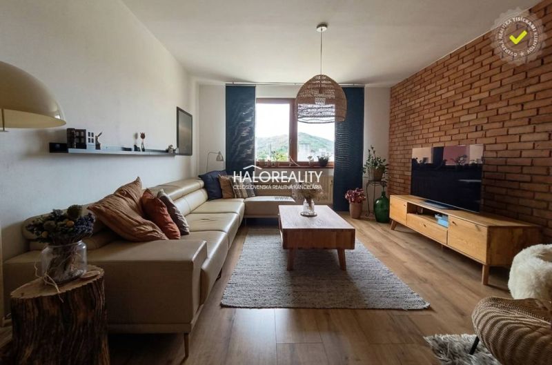 Living room with a leather sofa, TV, and wooden decor flooring in a 3-room apartment.