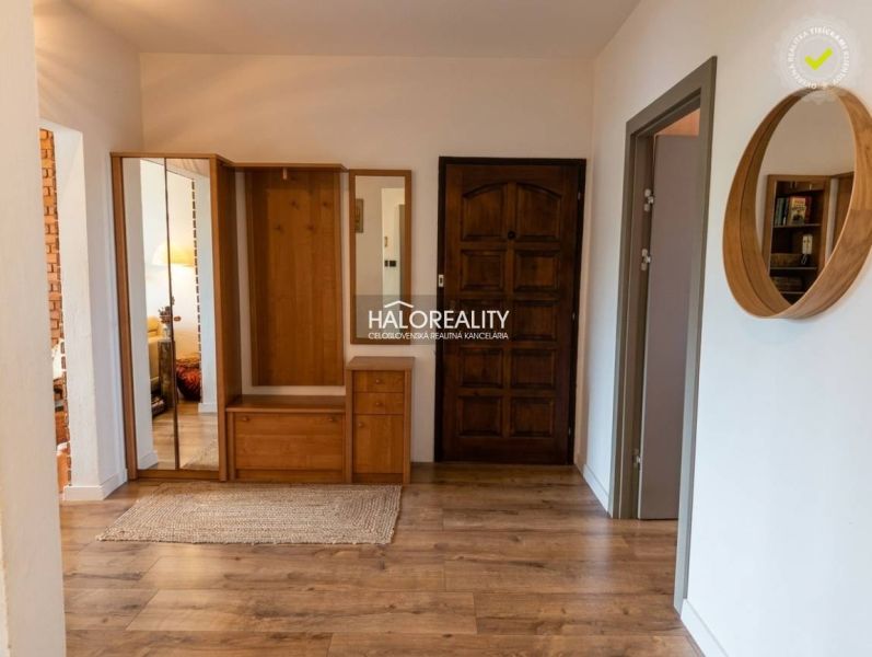 The entrance hall in a 3-room apartment with a wooden decor floor and wooden cabinets.