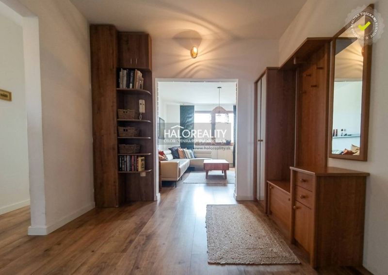 Entrance hall in a 3-room apartment, wooden decor flooring, bookshelf, bright living room.