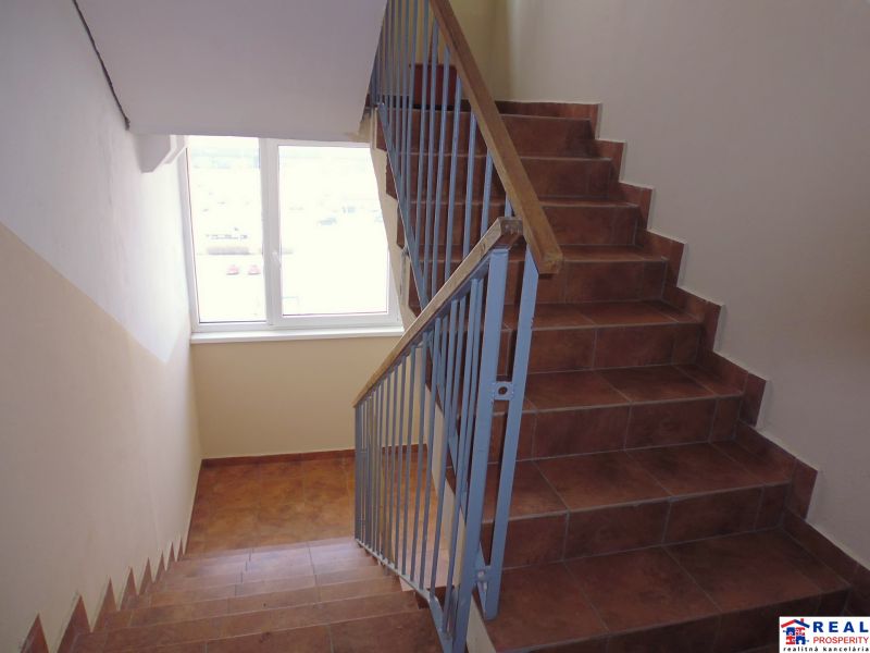 A staircase with a window and railing in a 2-room apartment.