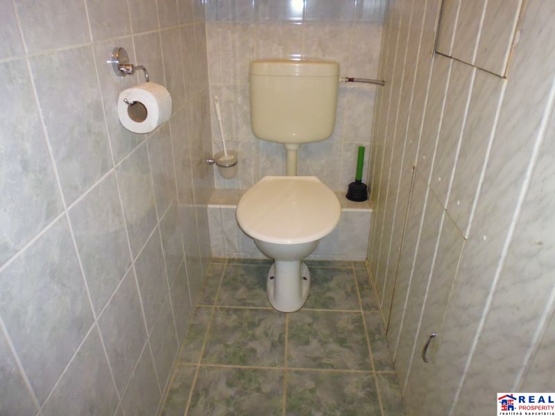 Bathroom with toilet in a 2-room apartment with tiled walls and floor.