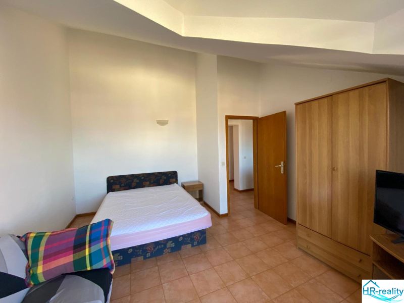 A bedroom in a holiday apartment with a bed, wardrobe, and television.
