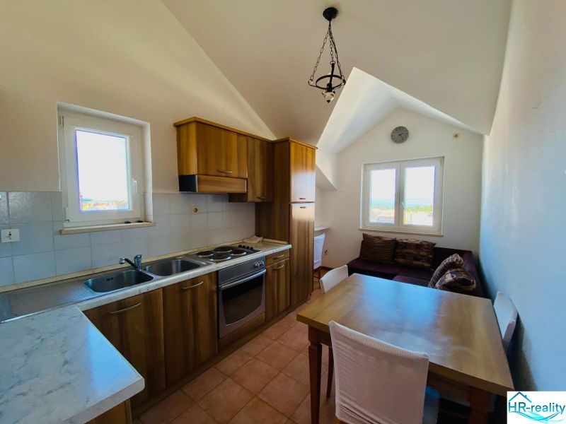 A kitchen with wooden decor, a dining table, and a sofa in a holiday apartment.