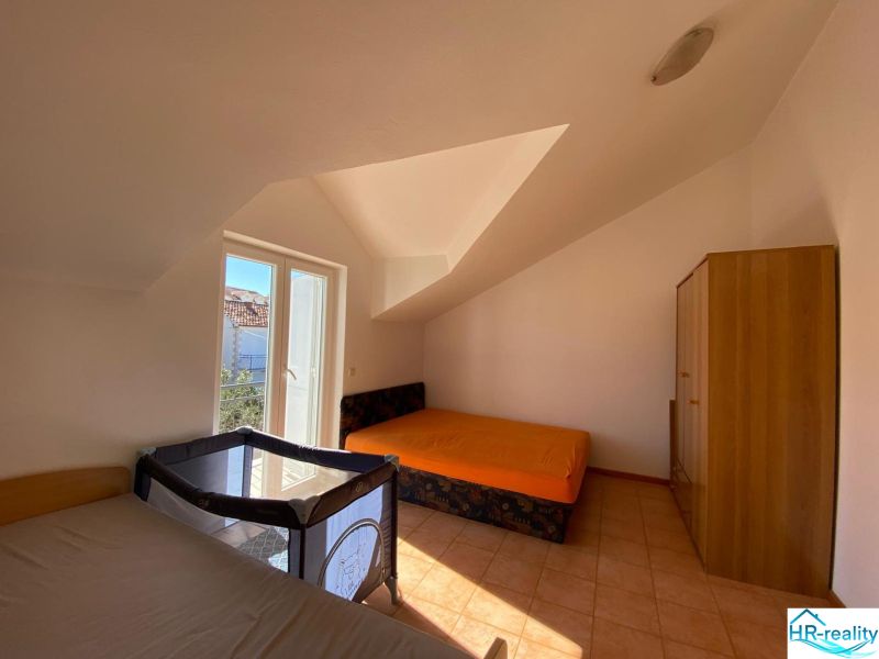 Bedroom in a holiday apartment with beds, a wardrobe, and a crib.