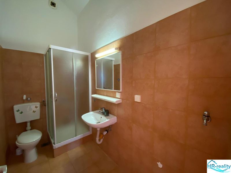 A bathroom in a holiday apartment with a sink and a shower.