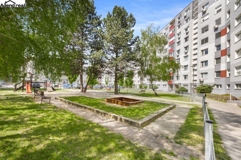 A courtyard full of greenery with benches and a sandbox on Kríková Street, Bratislava - Vrakuňa.