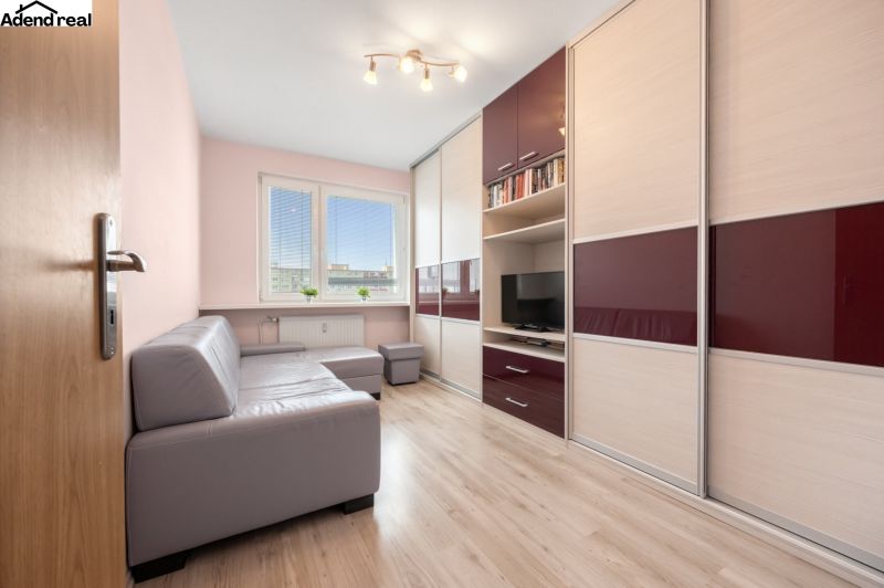 Living room in a 3-room apartment with a wooden decor floor and a corner sofa.