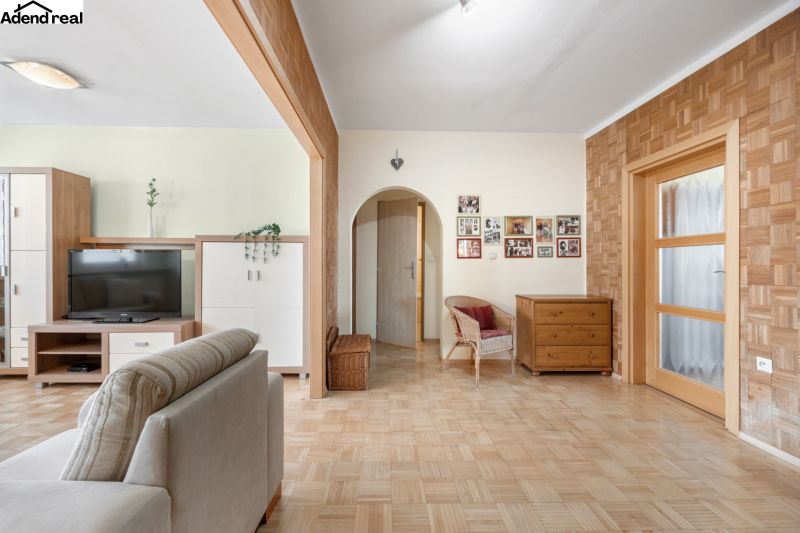 Living room in a three-room apartment with a wooden decor floor and furniture.
