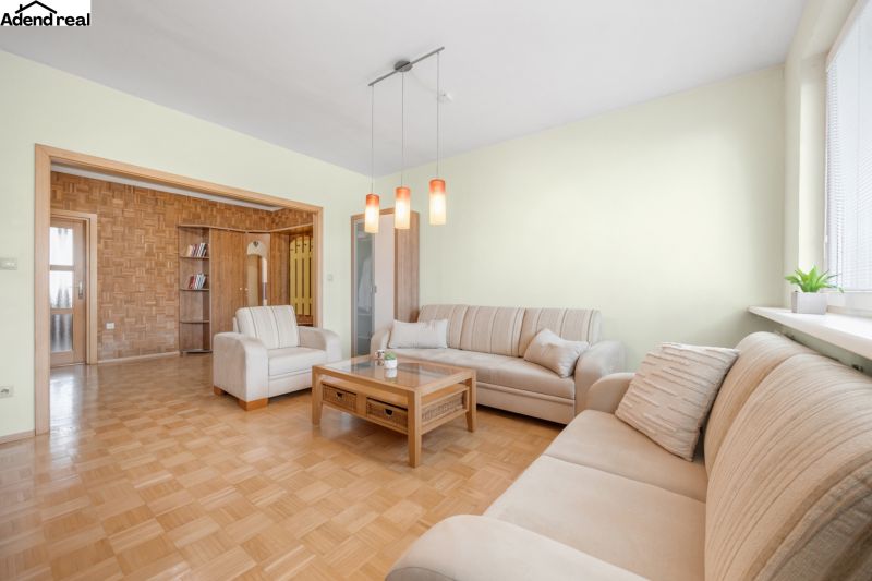 Living room in a 3-room apartment with sofas and a wooden decor floor.