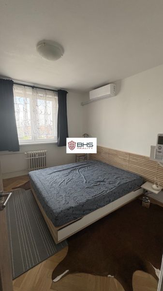 Bedroom in a two-room apartment with carpets on the floor with a wooden decor.