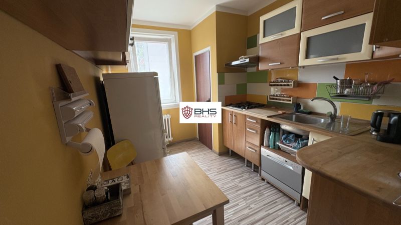 The kitchen of a 2-room apartment, equipped kitchen unit and floor with a wooden decor.