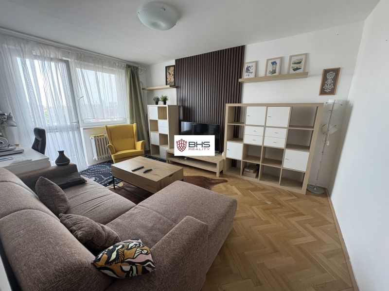 Living room in a two-room apartment with a comfortable sofa and a wooden decor floor.