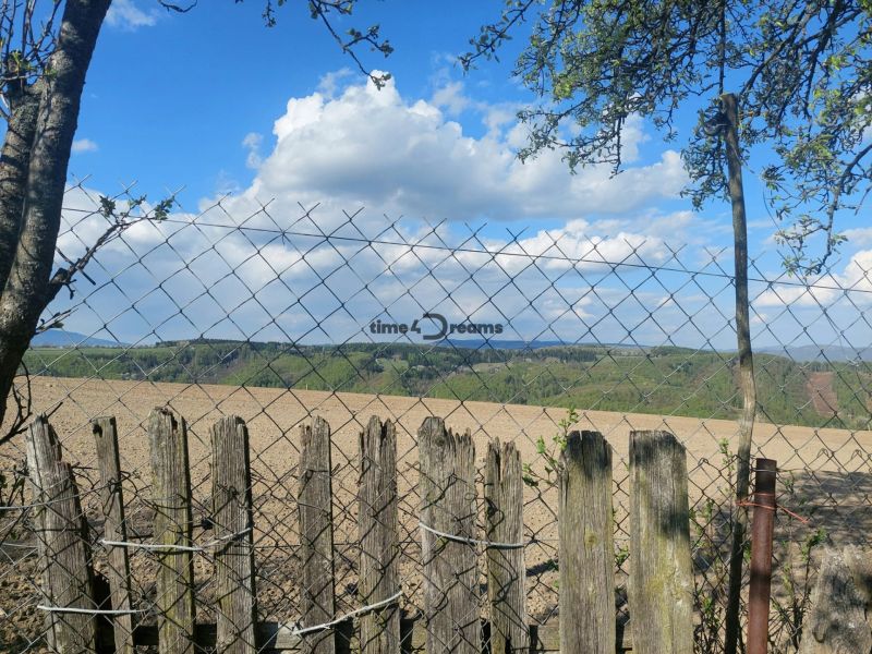 View of fields and hills in Budiná, surrounded by fencing; Land - housing.
