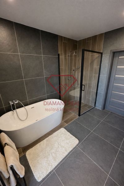 A bathroom in a family house with a freestanding bathtub and a shower enclosure.