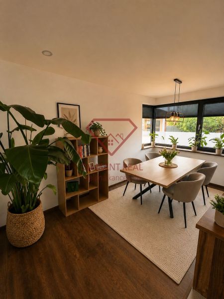 A dining room in a family house with wooden decor, plants, and a large window.