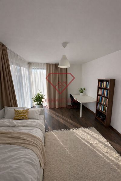 Interior of a family house with a bright room, a bed, and a floor with a wooden decor.