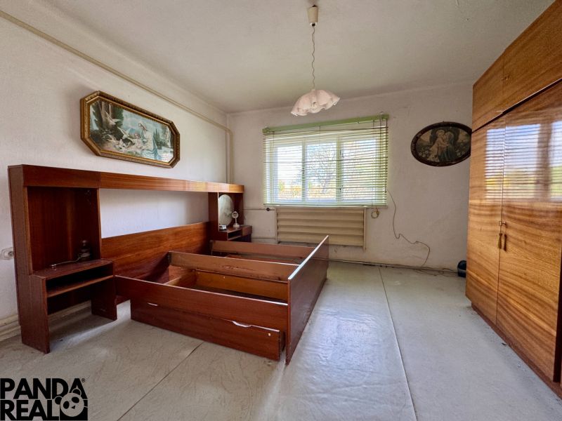 Bedroom in a family house with wooden furniture and a chandelier.