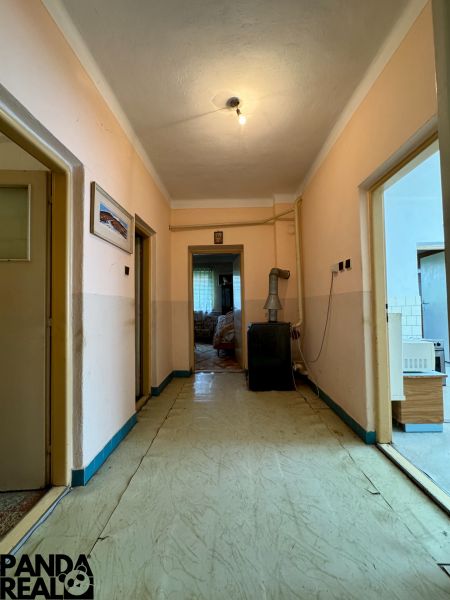 A hallway in a family house with simple lighting and an older interior design.