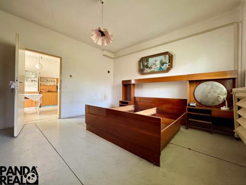 A room in a family house with retro furniture and open doors to the kitchen.